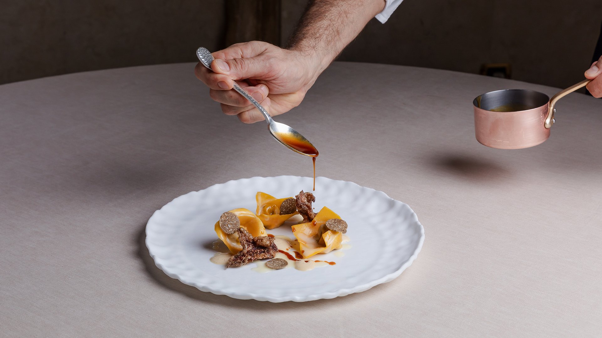 Piatto gourmet servito al Ristorante Amistà con sfoglia ripiena, tartufo e riduzione versata al momento