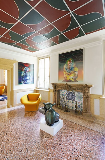 Scultura contemporanea e opere di Maurizio Cattelan nella Sala Paolini, con camino ornamentale e dettagli geometrici sul soffitto