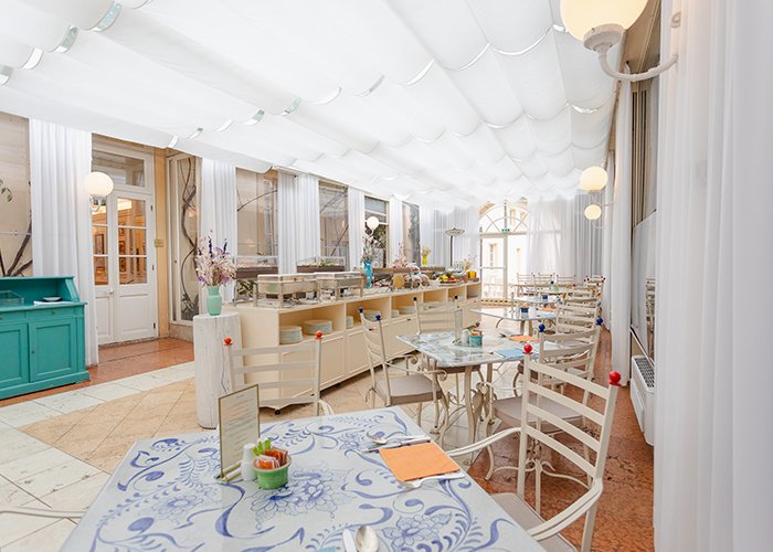 Veranda luminosa con tavoli per la colazione o pranzo in giardino