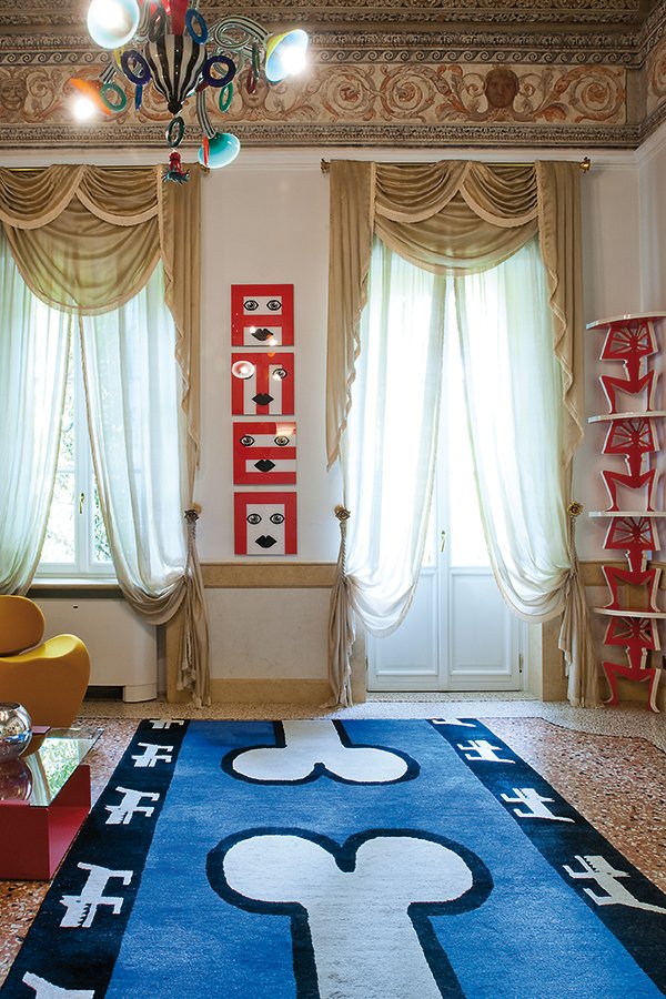 Dettaglio della sala Millar con poltrone colorate, tappeto grafico e opere Pop Art di Pierre et Gilles alle pareti del Byblos Art Hotel