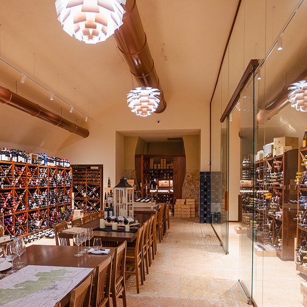 Vista laterale sulla cantina con pareti vetrate e bottiglie pregiate